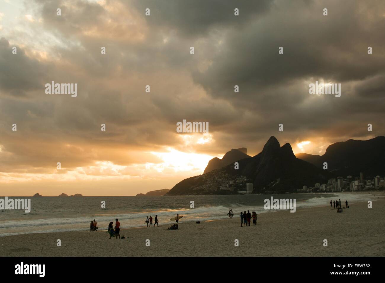 Menschen beobachten Sie den Sonnenuntergang am Arpoador Beach mit Pedra da Gávea (Gavea Rock) und Morro Dois Irmãos (zwei Brüder Hill) in der bac Stockfoto