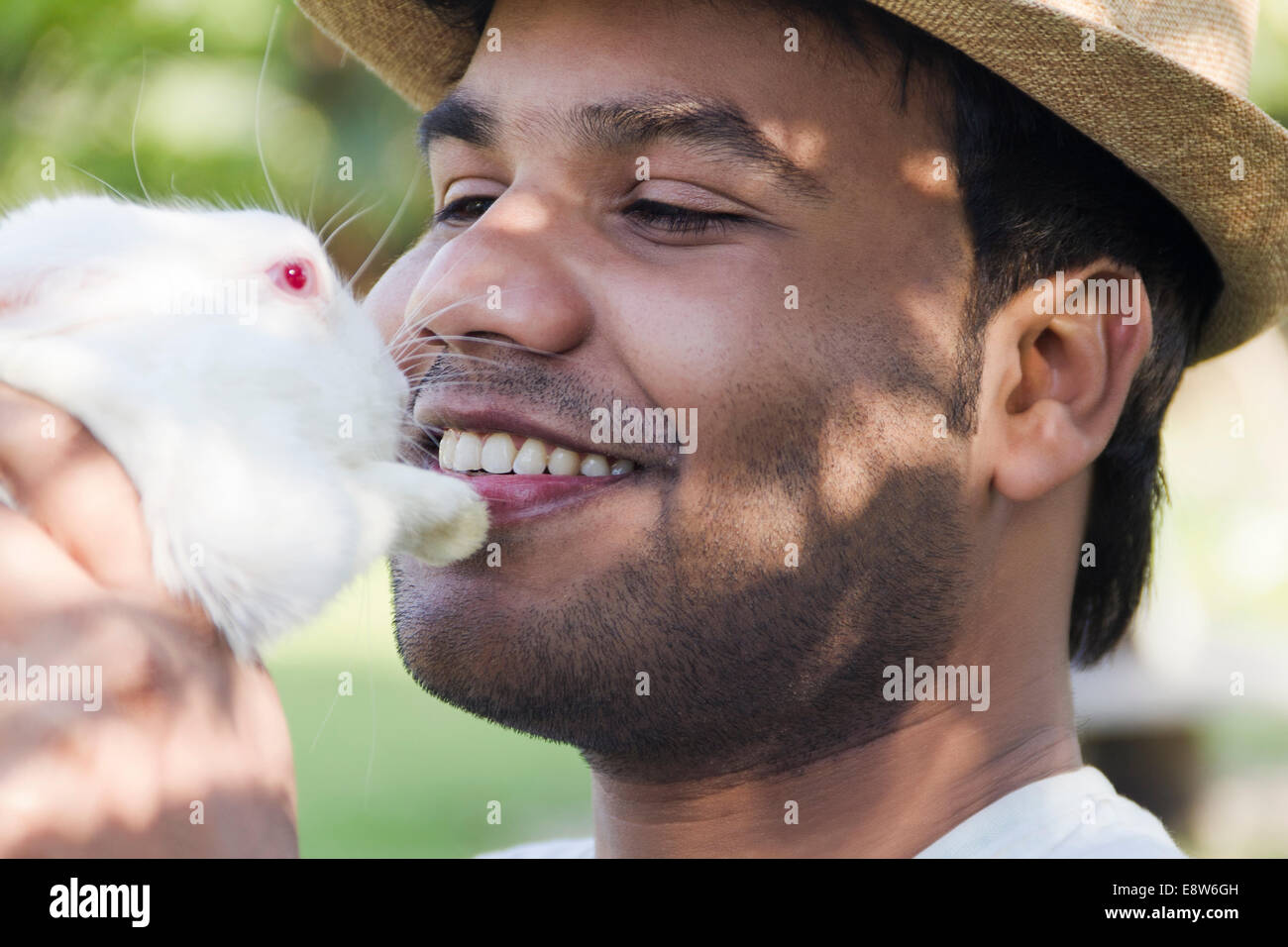 1 indischer Mann hielt mit Kaninchen Stockfoto