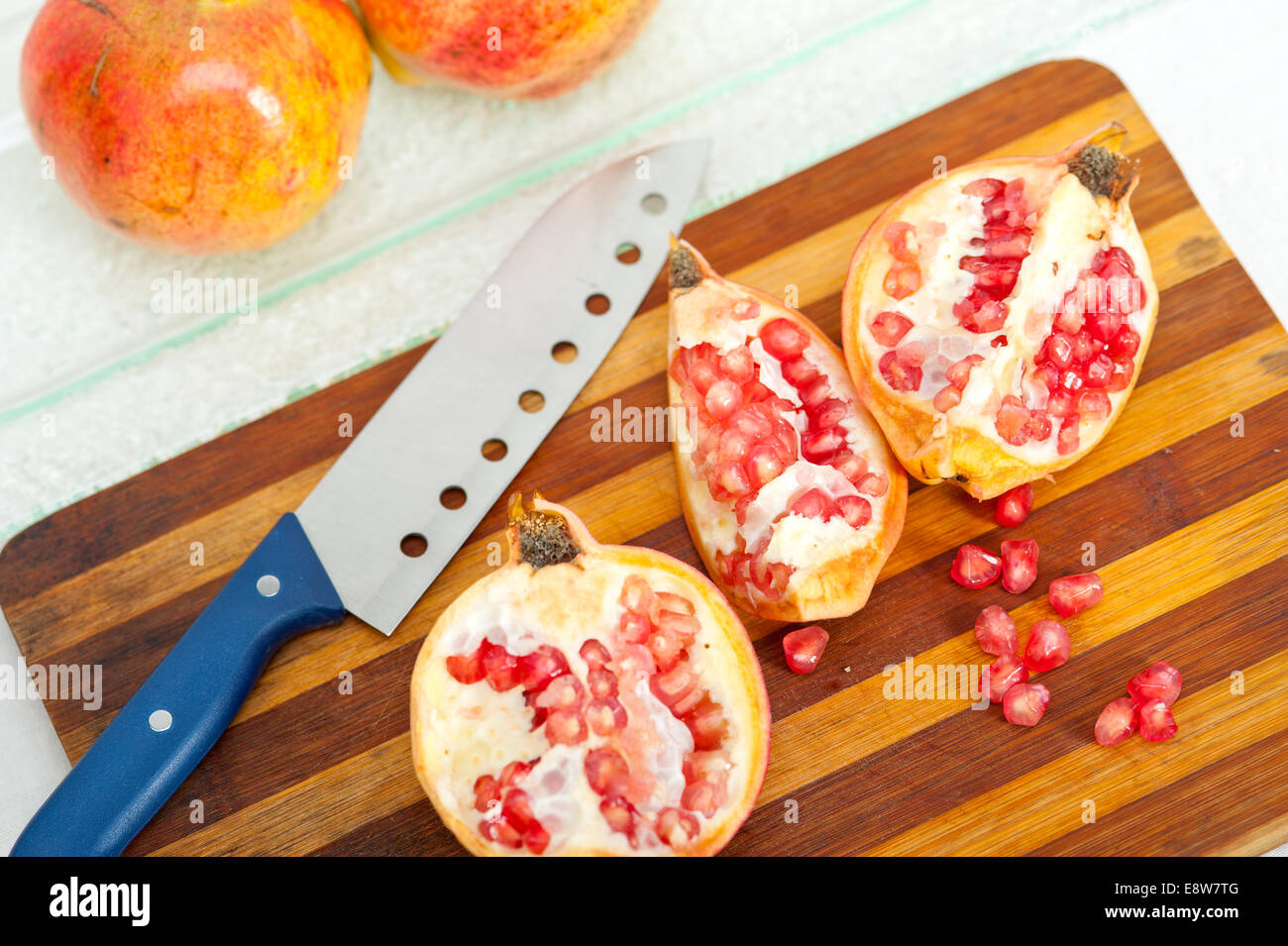 frischen Granatapfel-Frucht über Holz Schneidebrett mit Messer Stockfoto