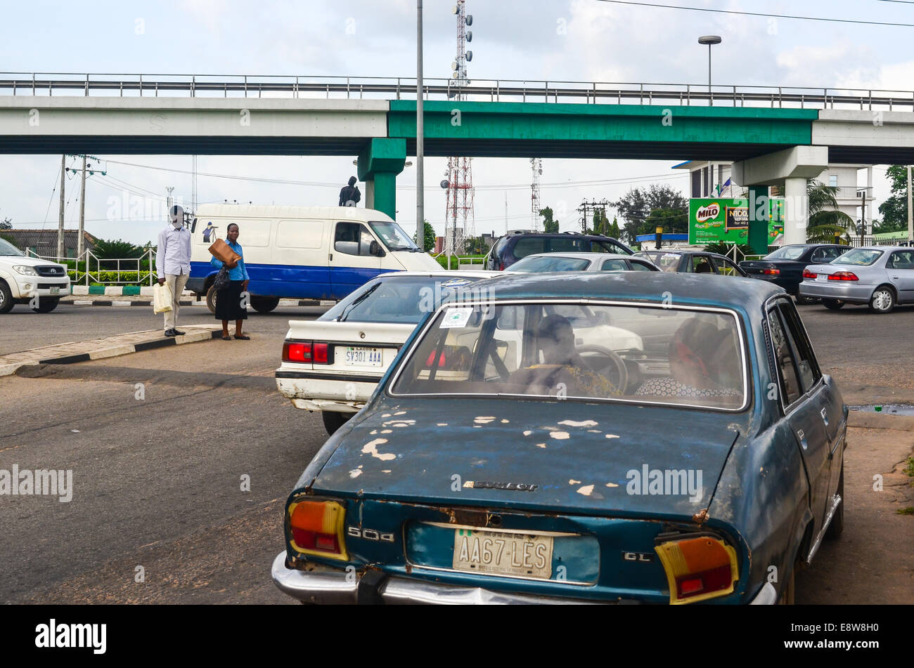 Eine alte Peugeot 504 und eine Brücke bemalt mit den Farben der nigerianischen Flagge in den Straßen der Stadt Ibadan, Oyo Zustand Stockfoto