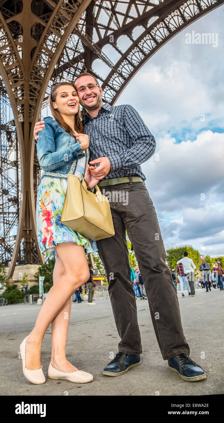 Junge Brautpaar posiert unter dem Eiffelturm in Paris. Stockfoto