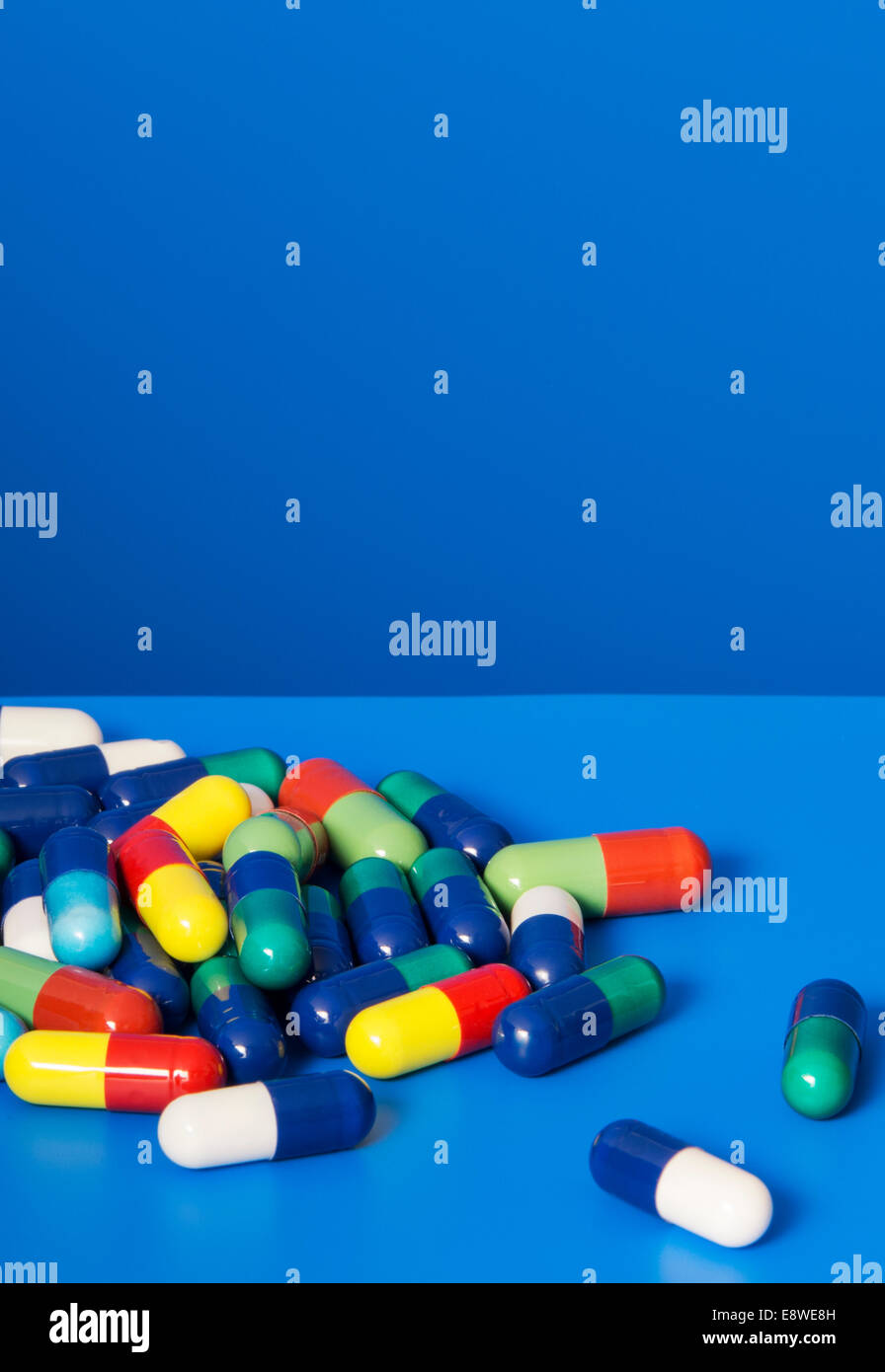 Nahaufnahme von Haufen von verschreibungspflichtigen Pillen auf blauem Hintergrund Stockfoto