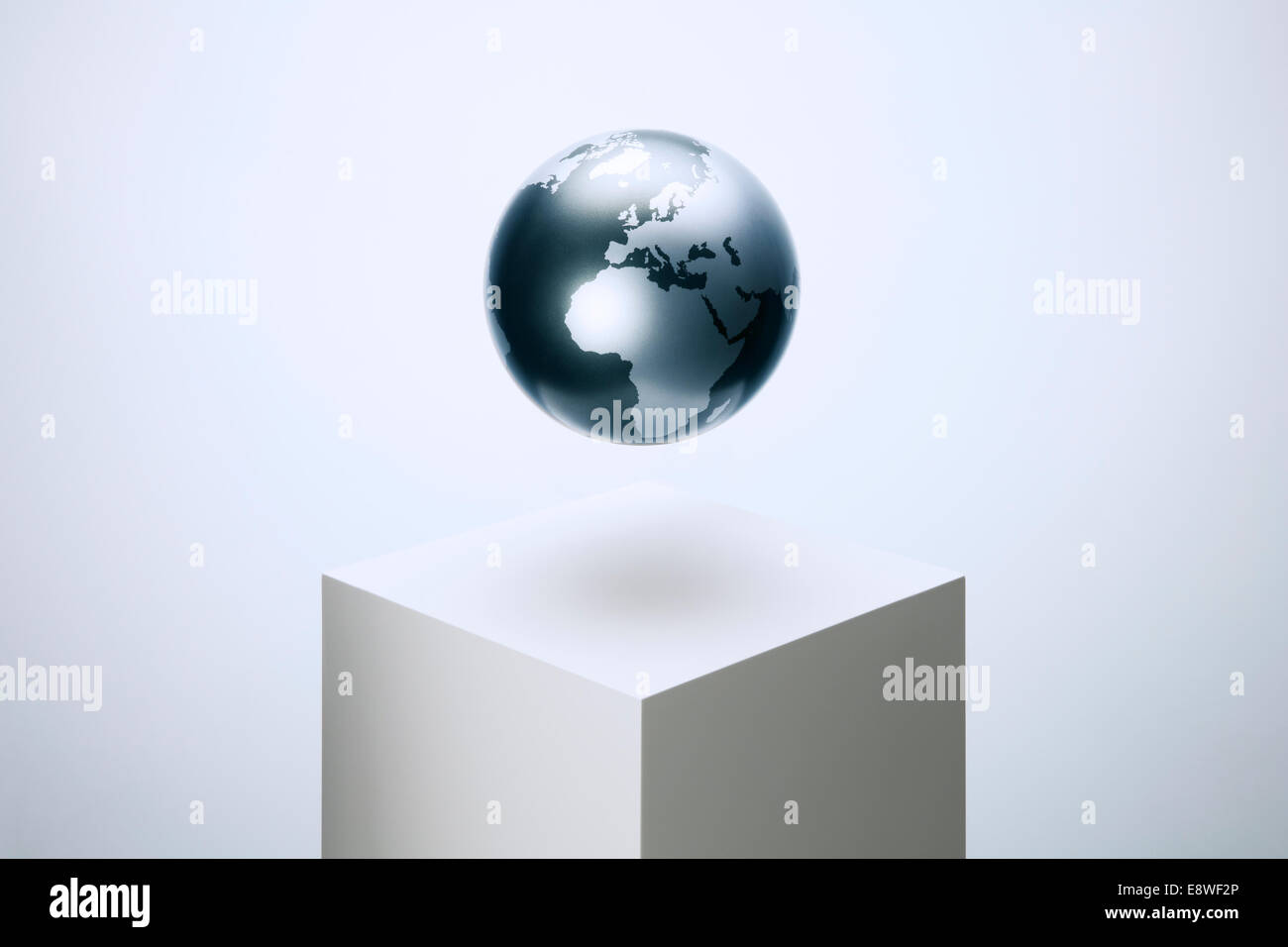 Globus schwebt über Sockel Stockfoto