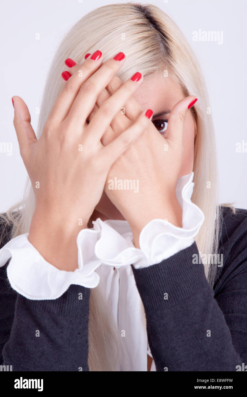Schöne junge Frau versteckt sein Gesicht mit Händen Stockfoto