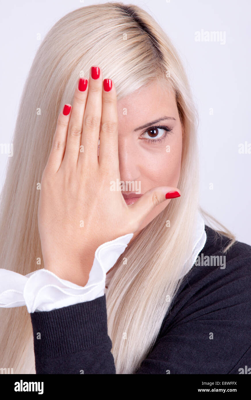 Schöne junge Frau versteckt sein Gesicht mit Händen Stockfoto