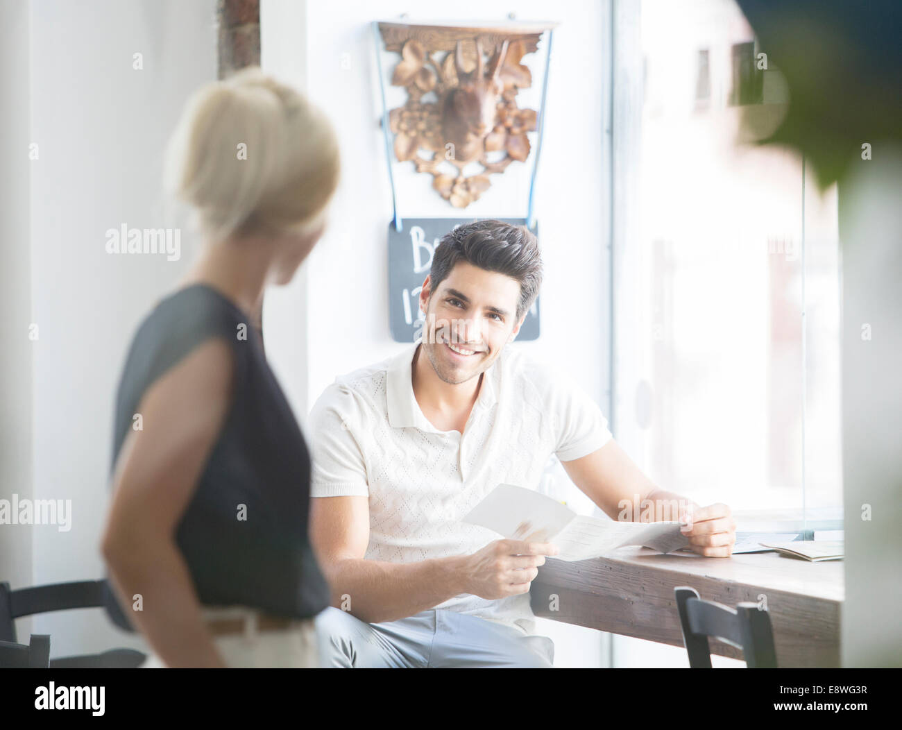 Mann, die Bestellung von Kellnerin im Café im Gespräch Stockfoto