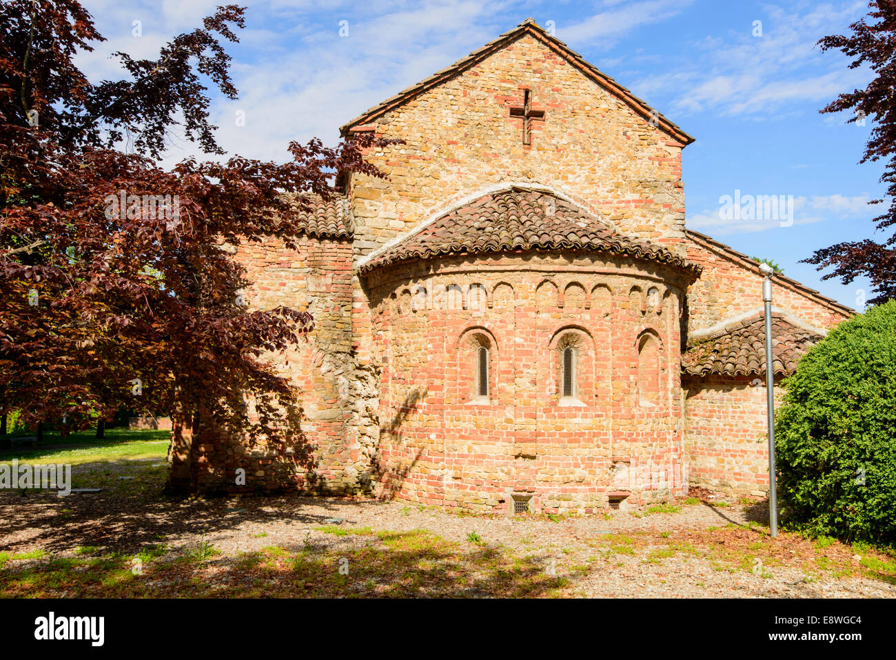 Außenansicht der Apsis und Südseite der alten romanischen Kirche im kleinen Dorf im Piemont, in hellen Frühling Licht gedreht Stockfoto