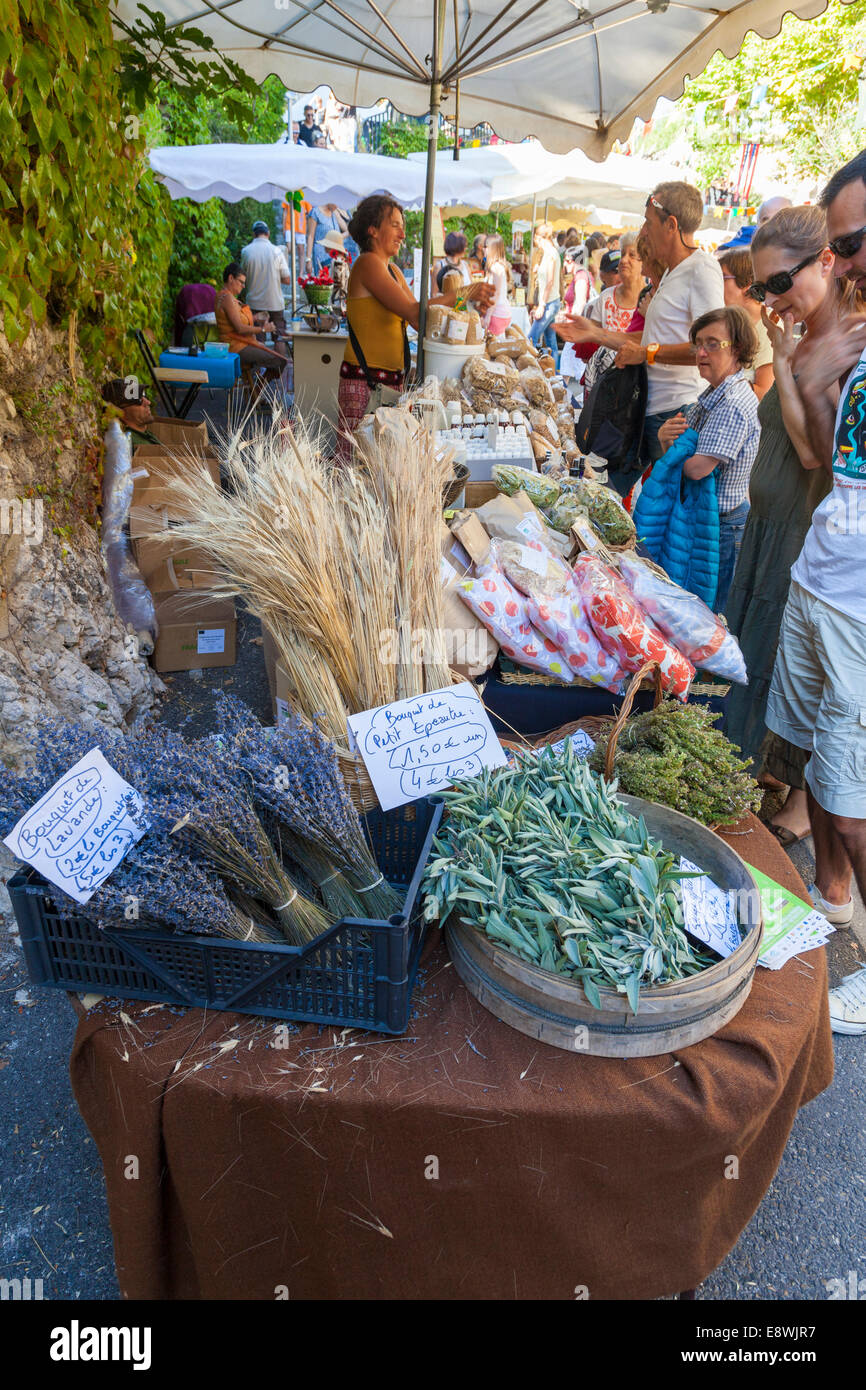 Markttag, Verkauf von Lavendel und anderen Gütern mit Käufern und Touristen, Monieux, Vaucluse, Provence, Frankreich. Stockfoto
