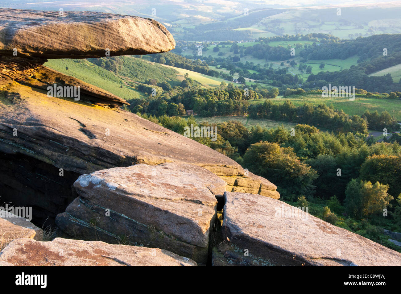 Gritstone Felsen auf Stanage Edge, Peak District. Blick auf grüne Landschaft unter. Stockfoto