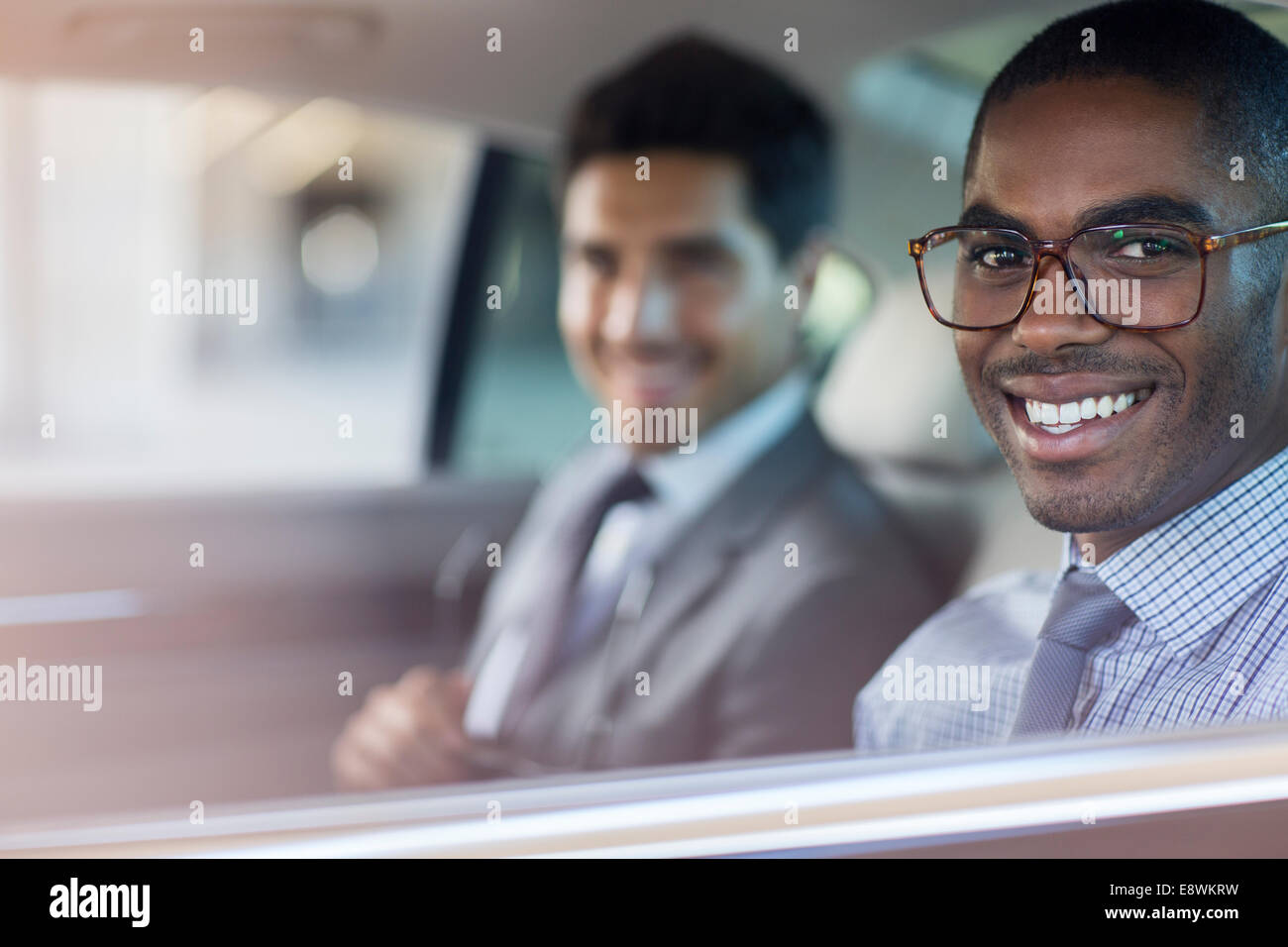 Lächelnde Geschäftsleute sitzen im Auto Stockfoto