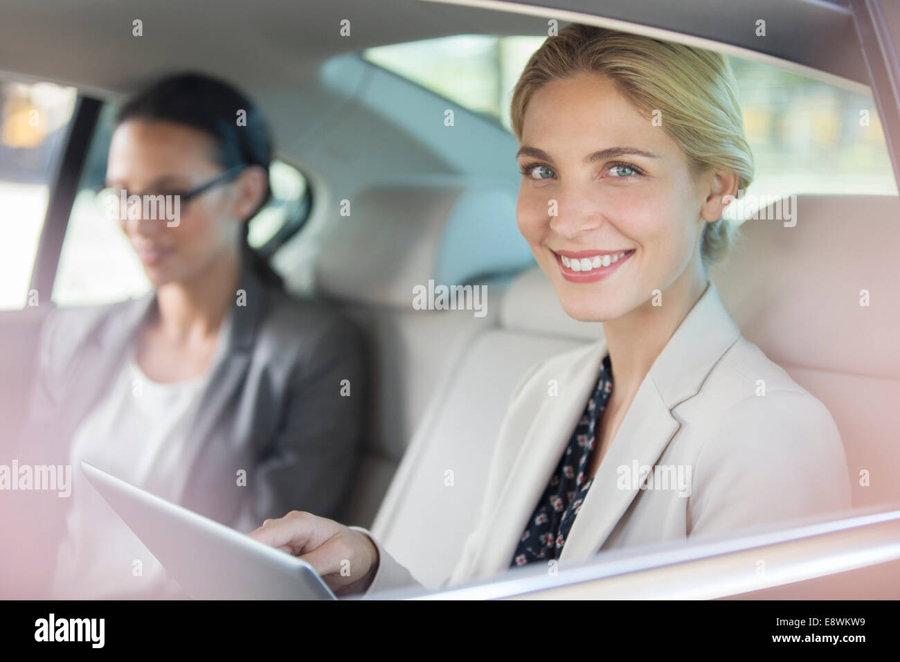 Geschäftsfrau mit digital-Tablette auf dem Auto Rücksitz Stockfoto