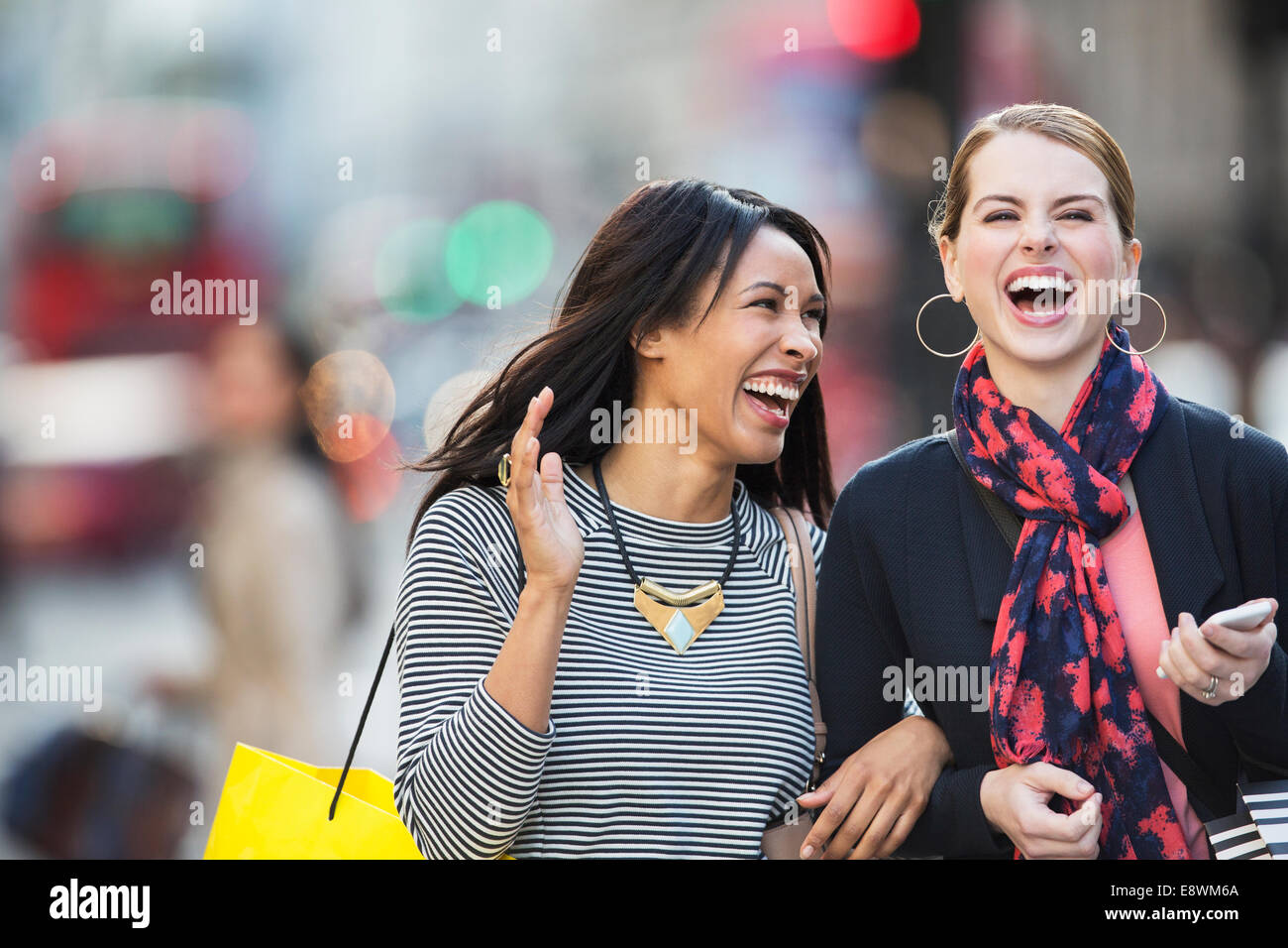 Frauen lachen zusammen hinunter Stadtstraße Stockfoto