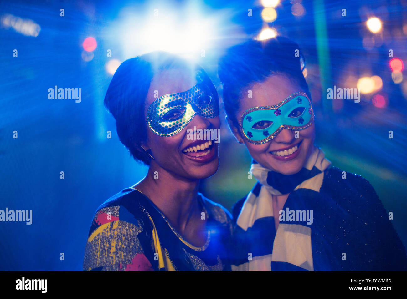 Frauen in Masken lächelnd zusammen Stockfoto