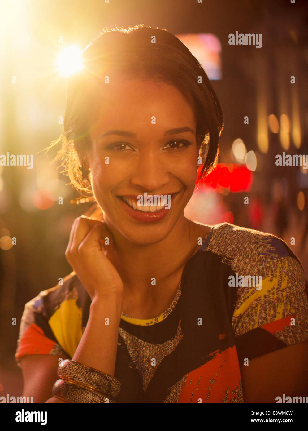 Frau lächelnd auf Stadtstraße in der Nacht Stockfoto