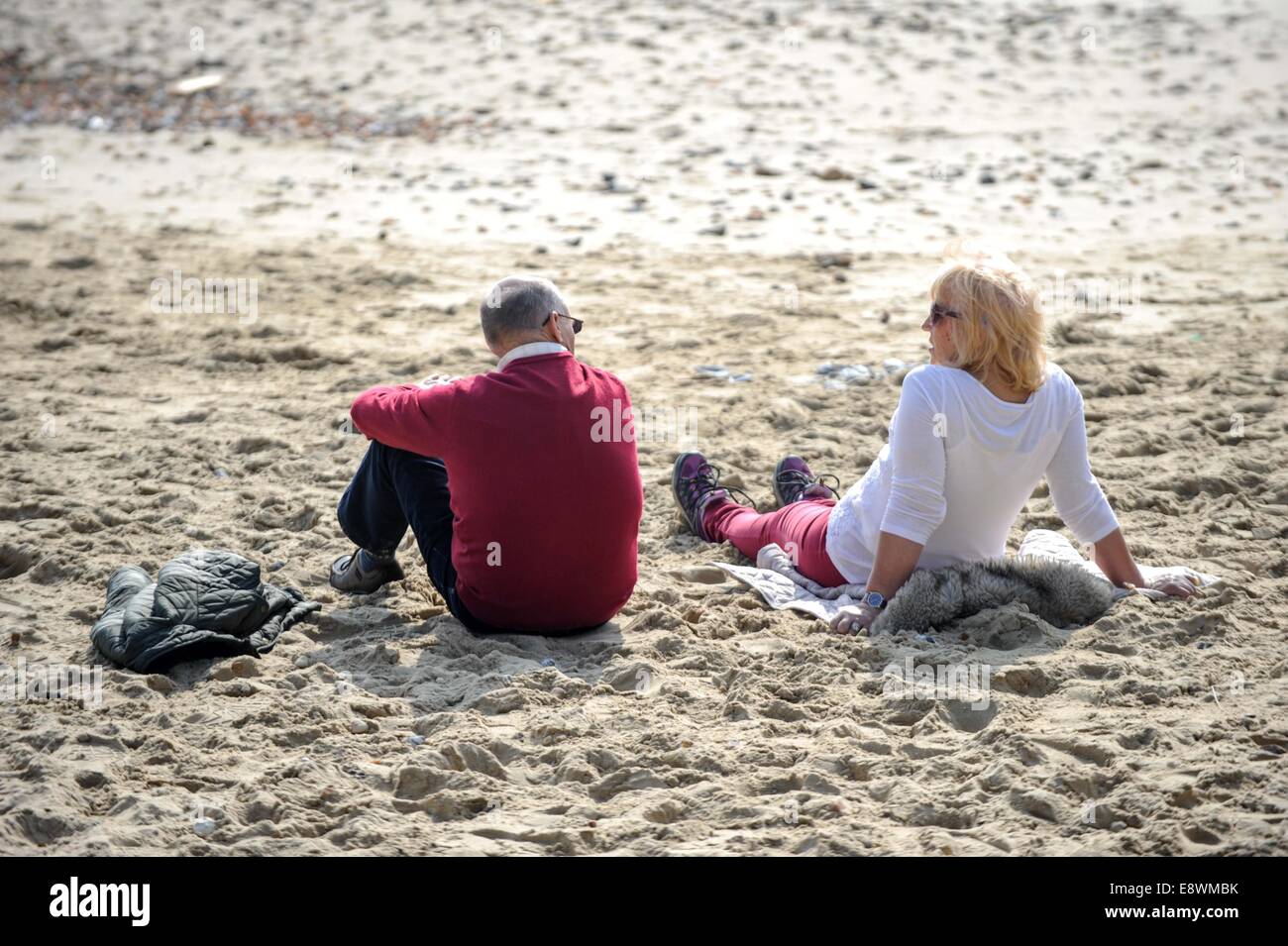 Entspannen in der Sonne am Strand von Bournemouth, England am 12. März 2014 ein paar gelten. Stockfoto