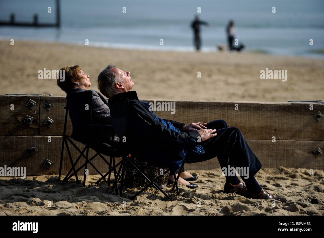 Ein paar gelten Entspannung in ihren Sitzen am Strand von Bournemouth, England am 12. März 2014 Stockfoto