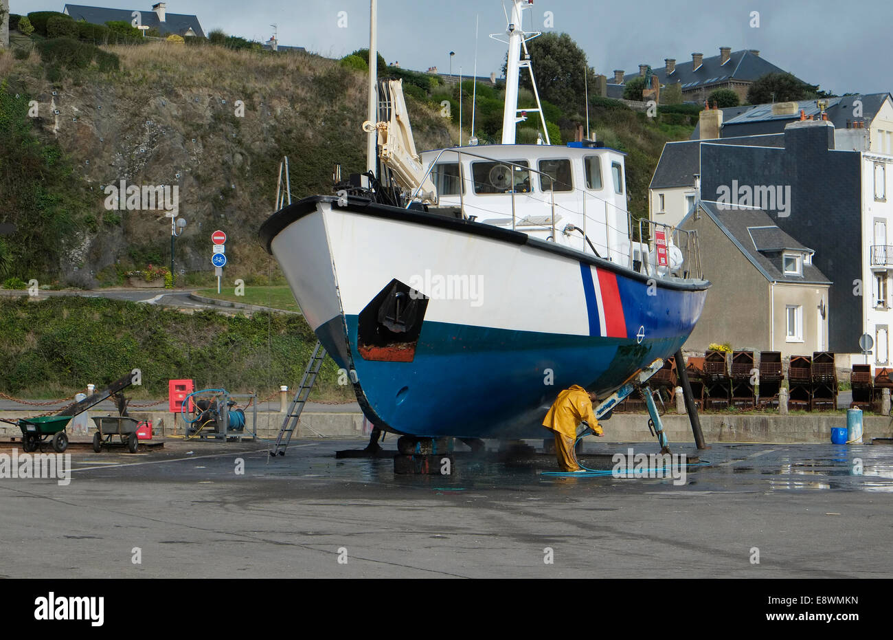 Mann Reinigung Rumpf der großen Boot, Granville, Normandie, Frankreich Stockfoto