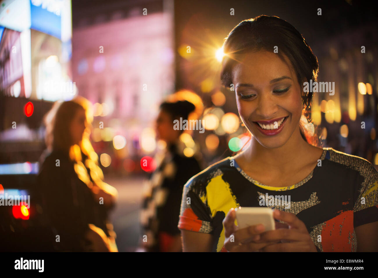 Frau mit Handy auf Stadtstraße in der Nacht Stockfoto
