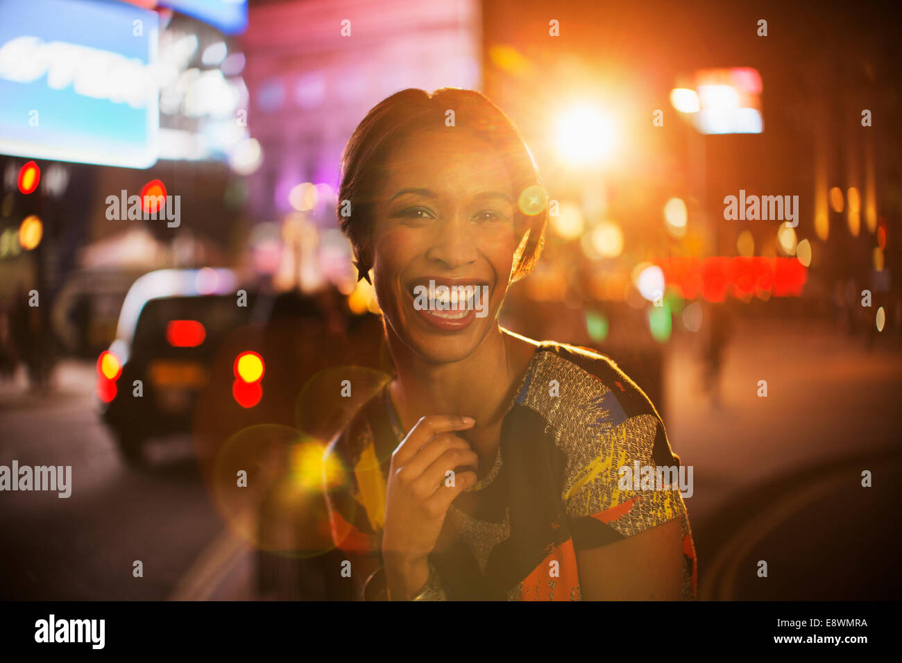 Frau lächelnd auf Stadtstraße in der Nacht Stockfoto