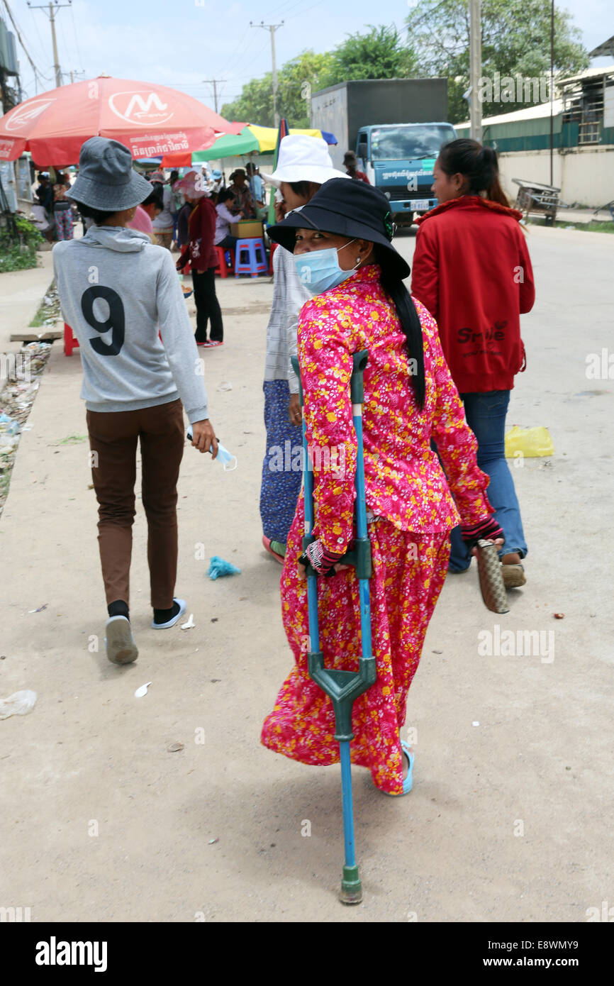 Behinderte Frauen Textil Arbeiter Schichtwechsel außerhalb einer Textilfabrik in das Industriegebiet von Pochentong, Phnom Penh, Kambodscha. Stockfoto