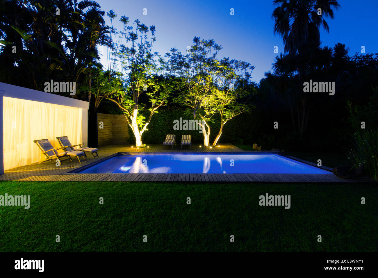 Beleuchteten Pool und Bäume im Hinterhof in der Abenddämmerung Stockfoto
