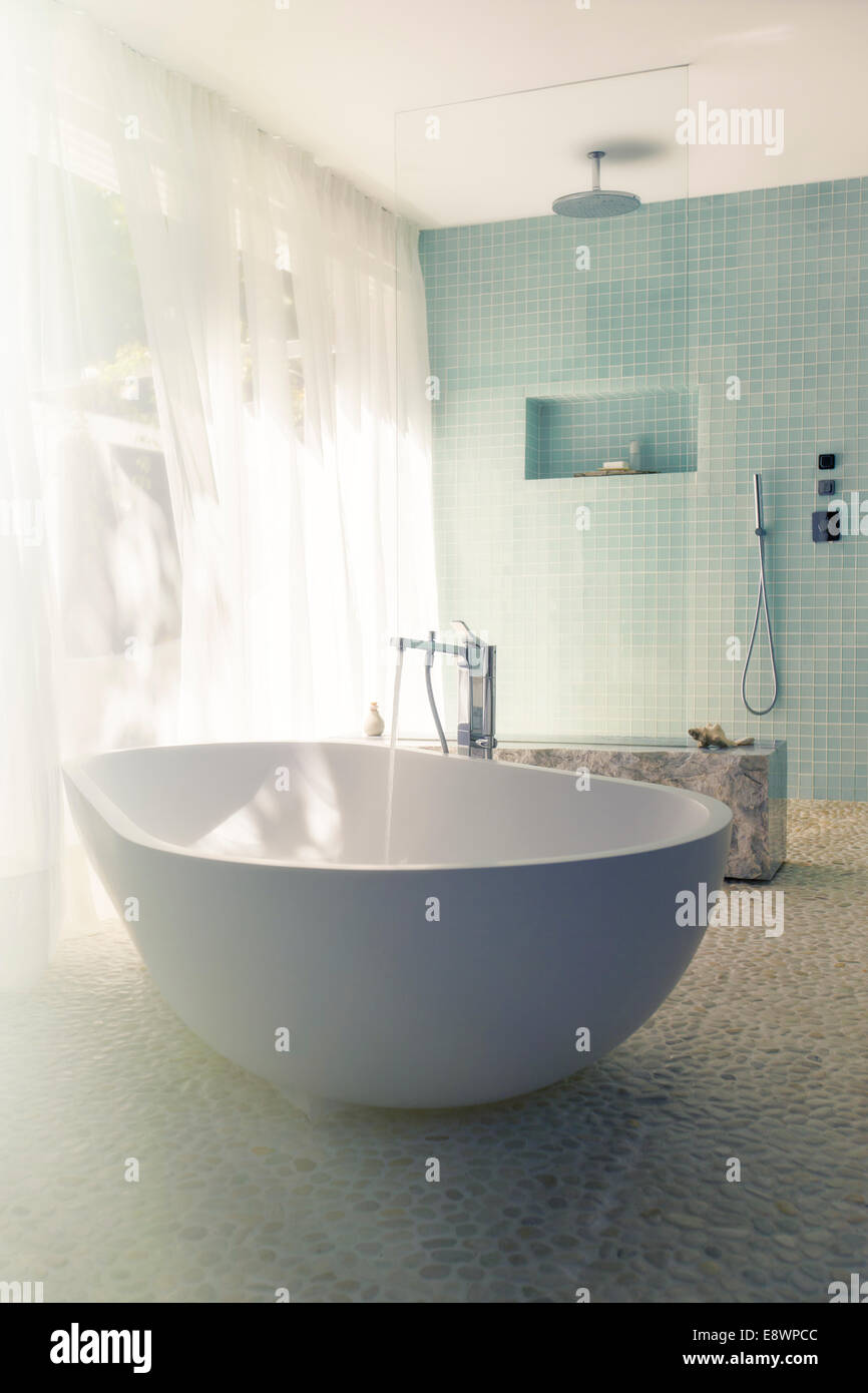 Wasser in Badewanne im modernen Bad gießen Stockfoto
