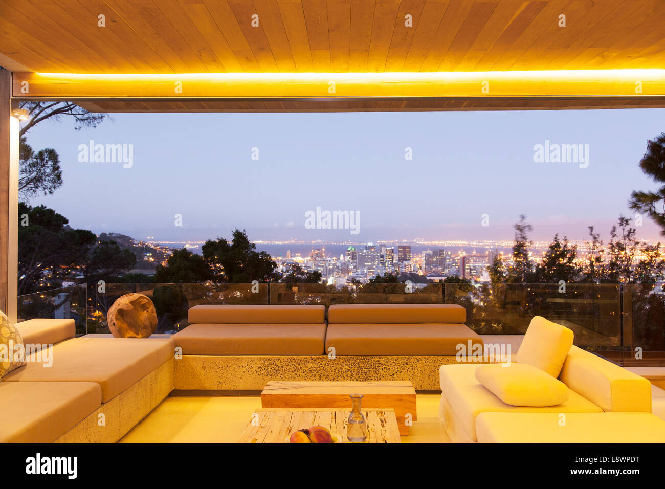 Modernes Wohnzimmer mit Blick auf beleuchtete Stadtbild bei Nacht Stockfoto