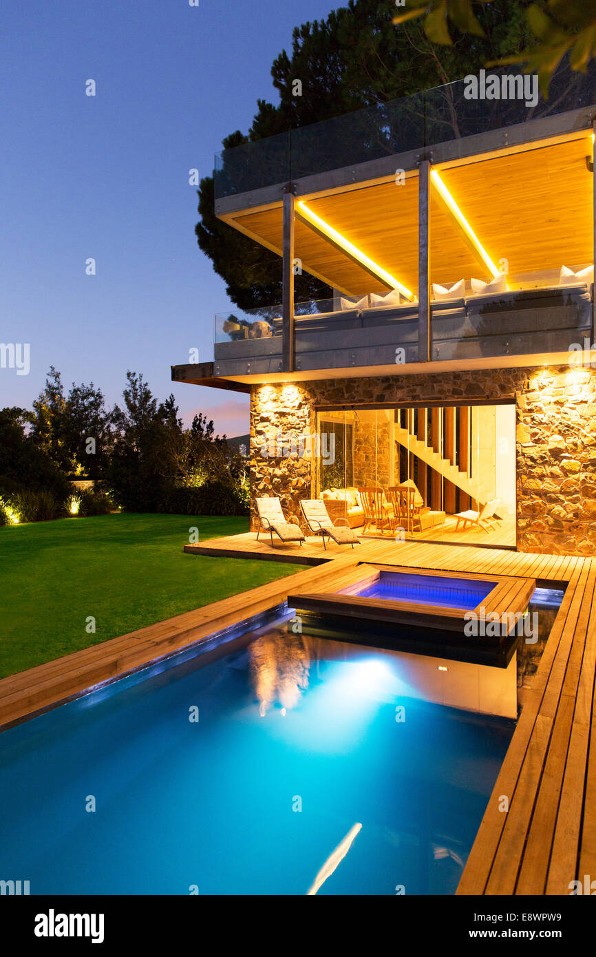 Modernes Haus mit Blick auf beleuchtet Swimmingpool nachts Stockfoto