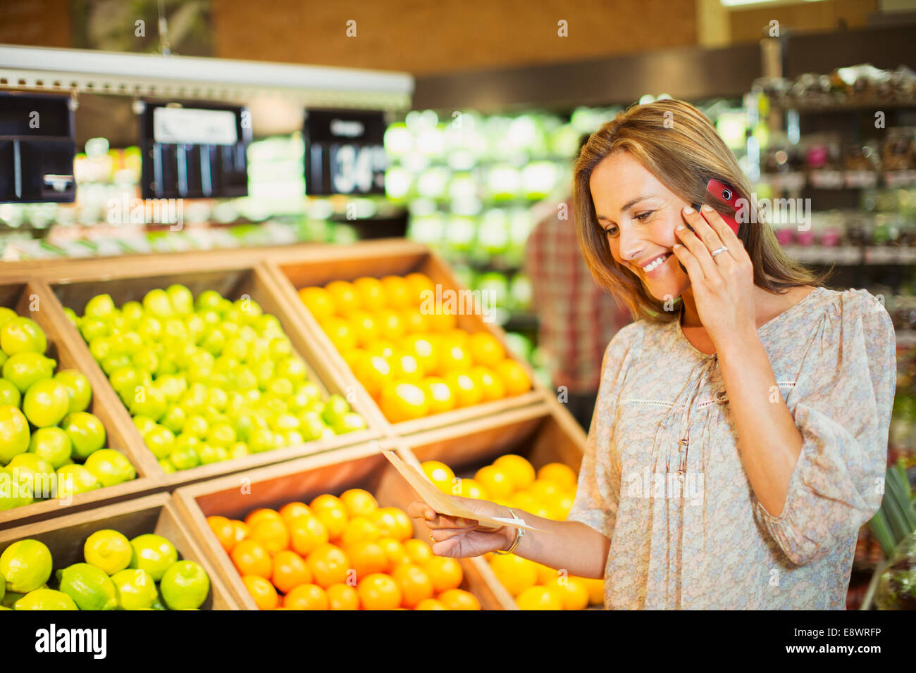 Frau am Handy während des Einkaufs im Supermarkt Stockfoto
