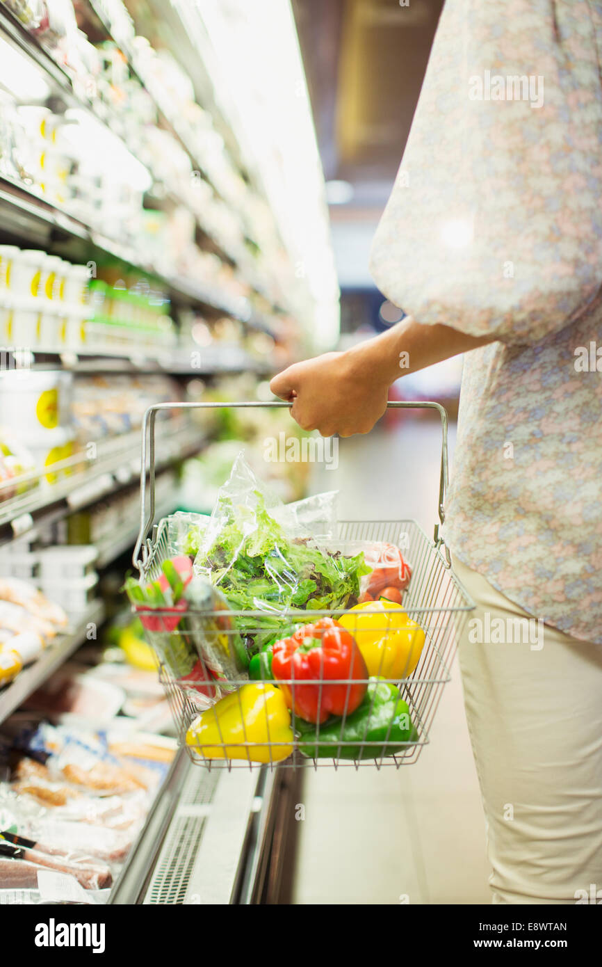 Frau mit vollen Einkaufswagen im Supermarkt Stockfoto