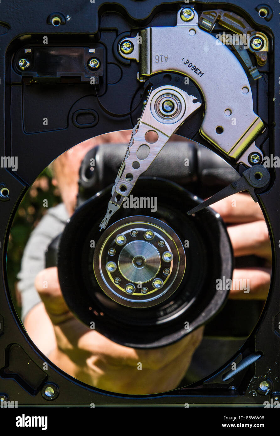 Eine Reflexion eines Fotografen mit einer Kamera spiegelt sich in einer Festplatte-Walze Stockfoto
