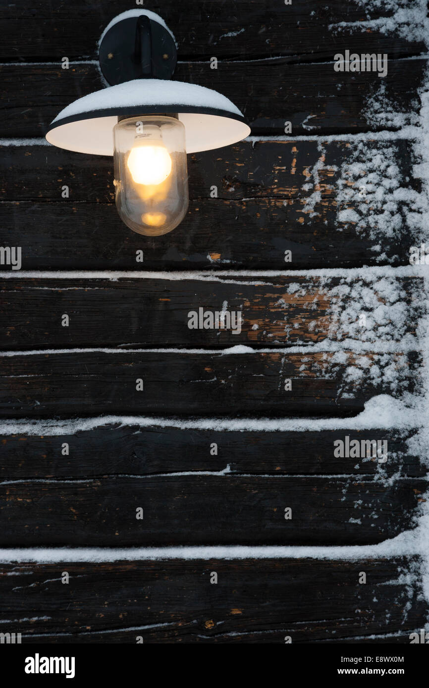 JAVRE, Schweden Detail des elektrischen Lichts hängen Holzhütte im Schnee. Stockfoto