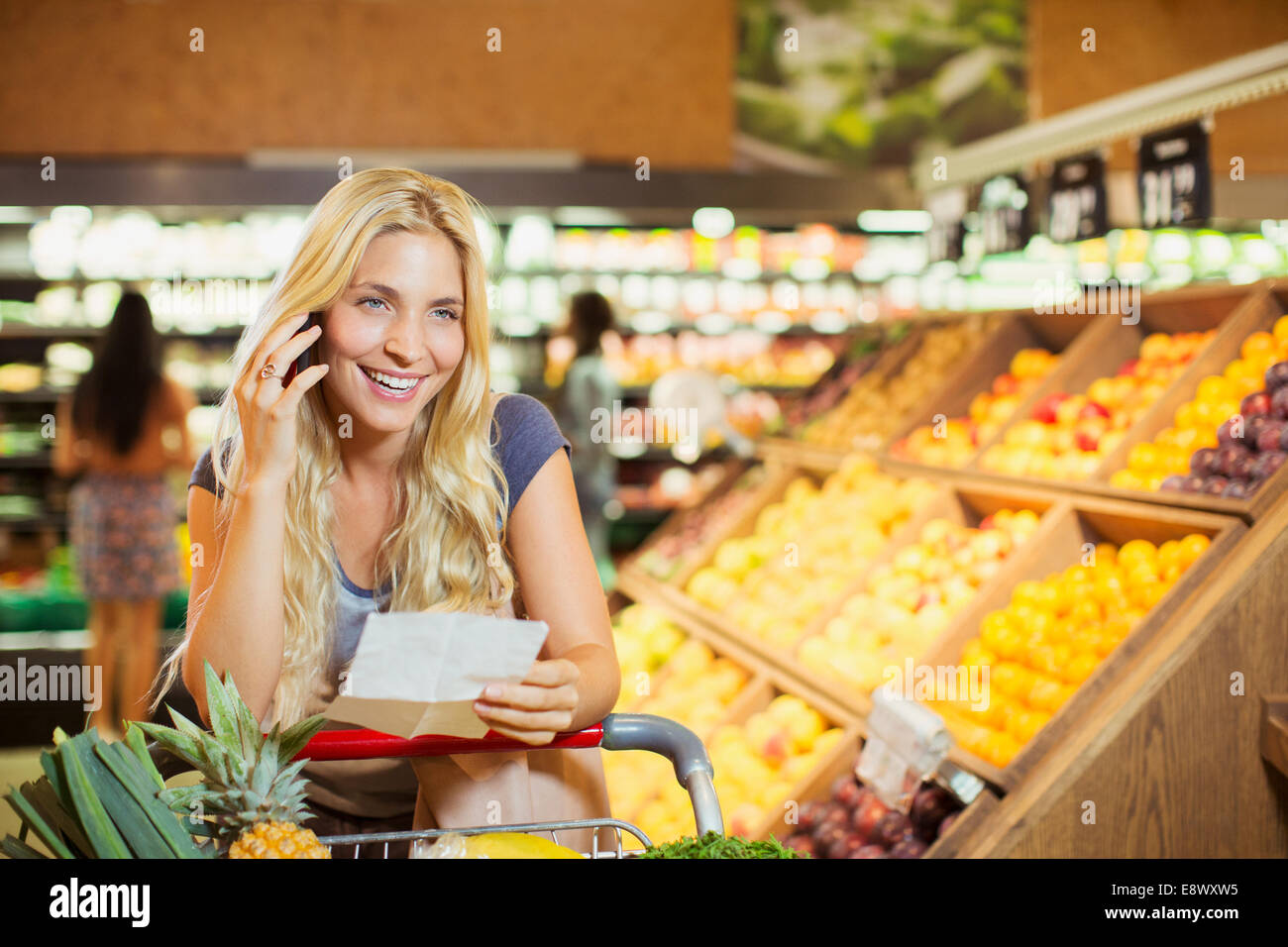 Frau am Handy im Supermarkt Stockfoto