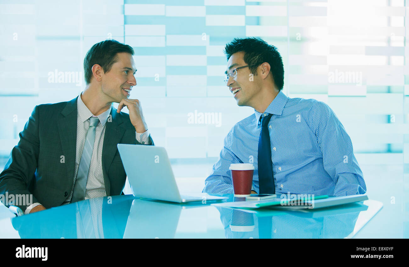 Unternehmer im Gespräch am Tisch im Bürogebäude Stockfoto