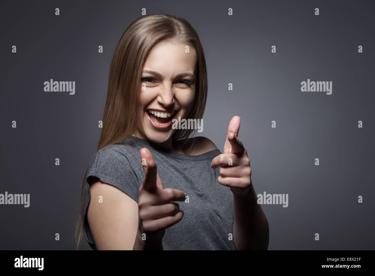 Lächelnde Frau mit Ordnung Geste auf dunkelgrau Stockfoto