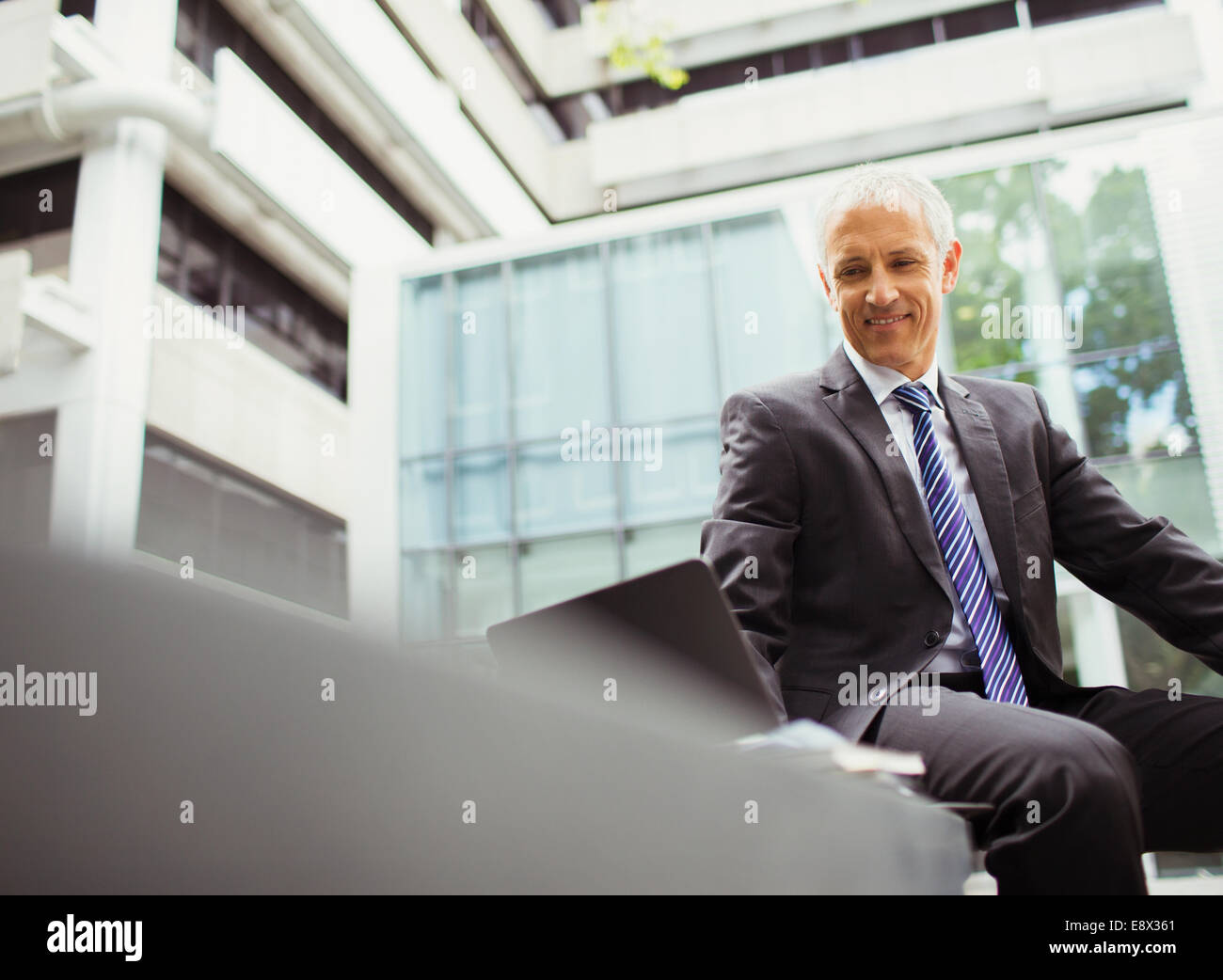 Geschäftsmann mit Laptop in Bürogebäude Stockfoto