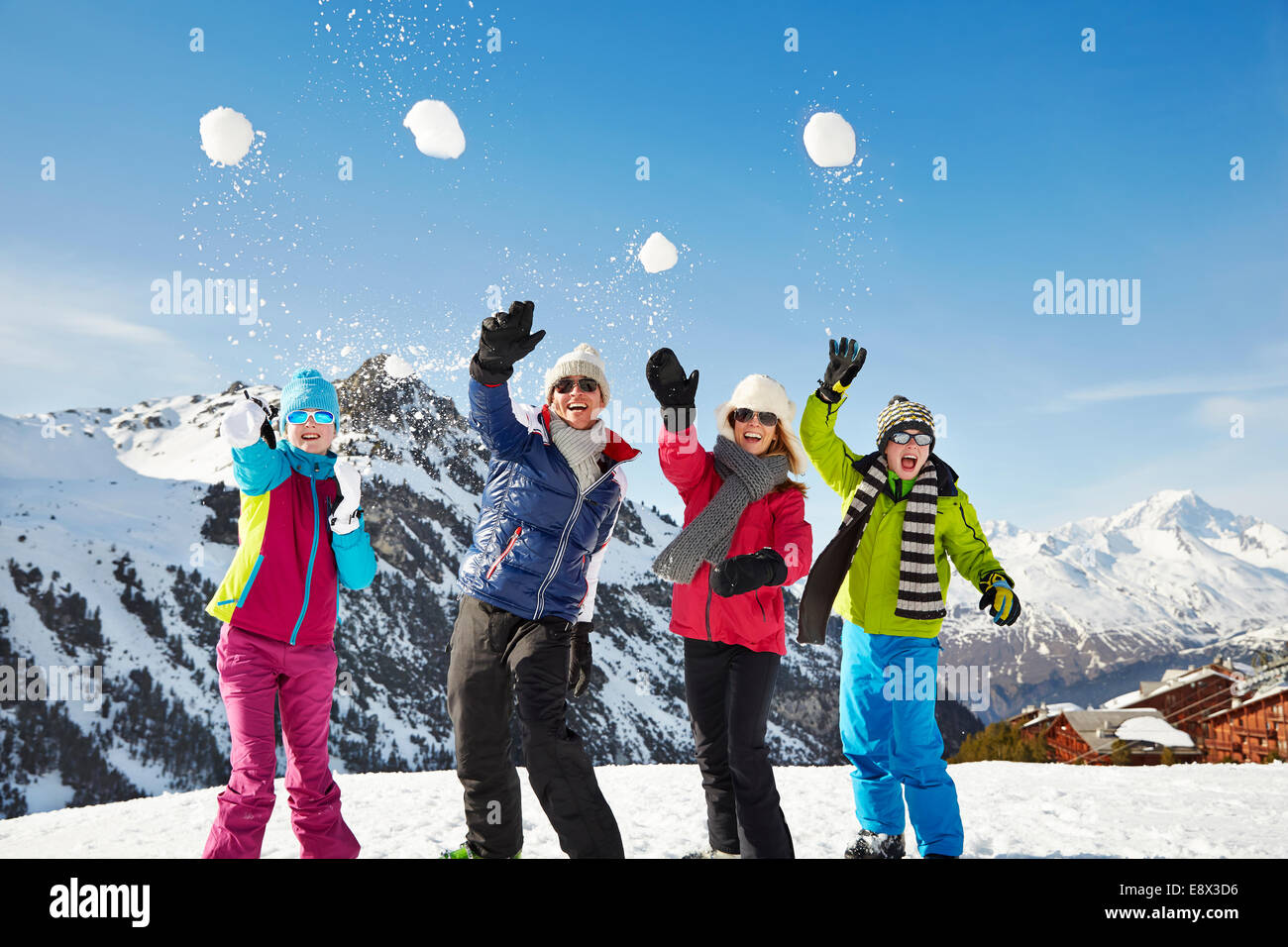 Familie werfen Schneebälle auf Berggipfel Stockfoto