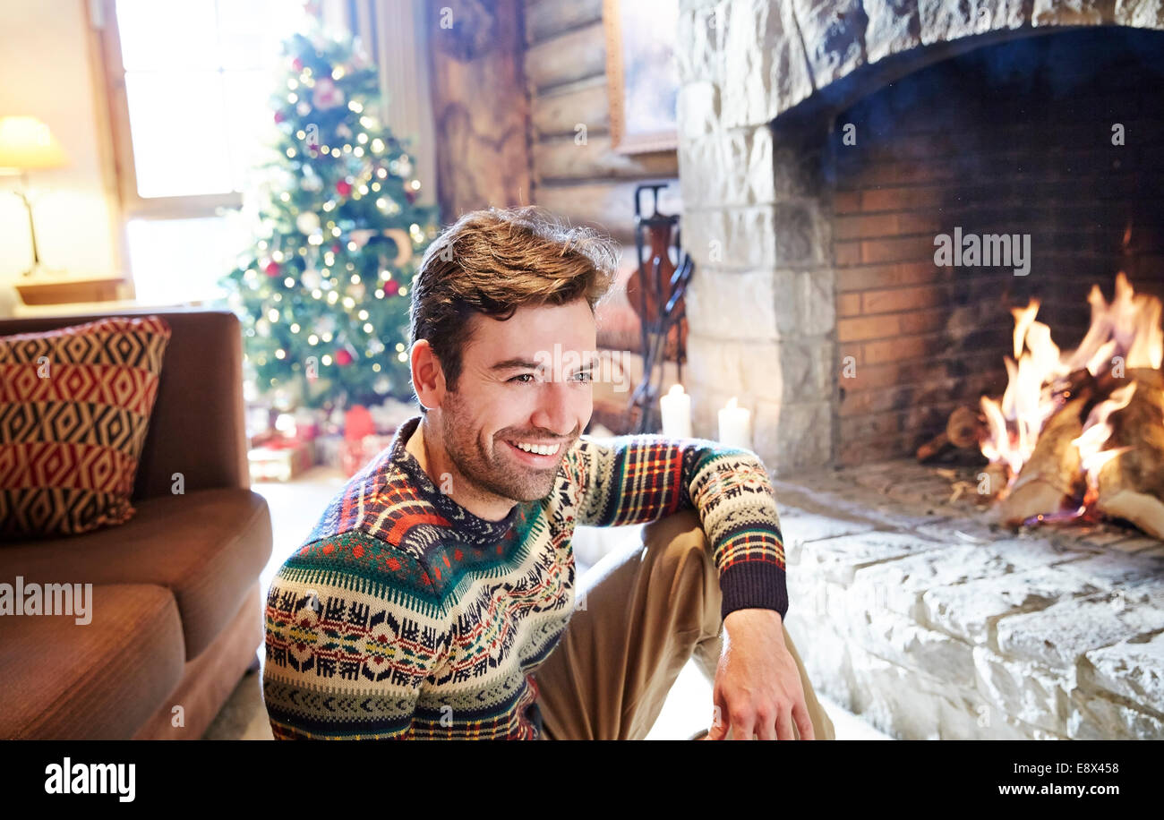 Mann in warmen Pullover Kamin genießen Stockfoto