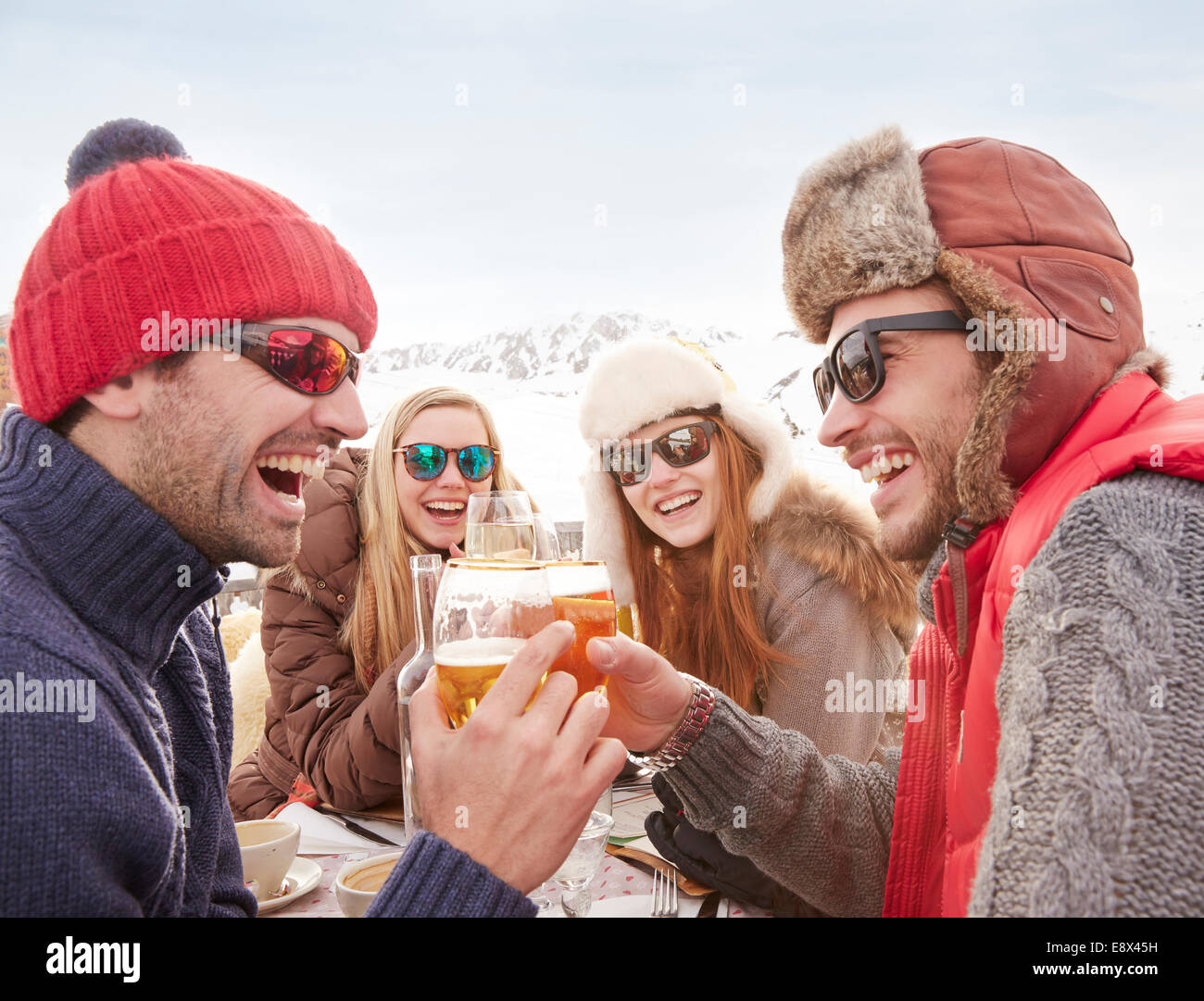Freunde feiern mit Getränken im Schnee Stockfoto