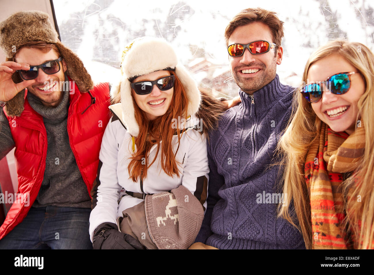 Freunde lächelnd zusammen am Skilift Stockfoto