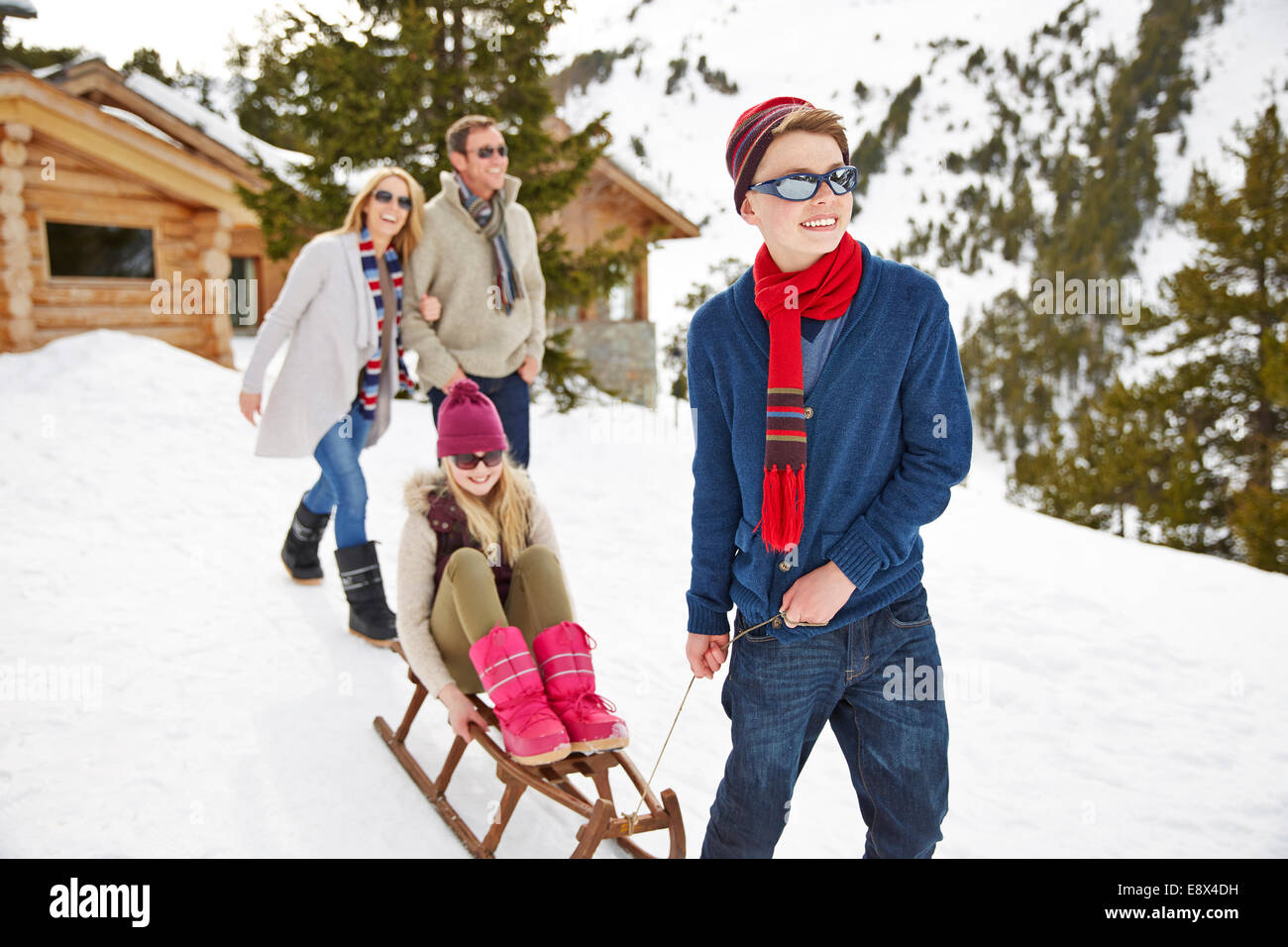 Bruder Schwester auf Schlitten im Schnee ziehen Stockfoto