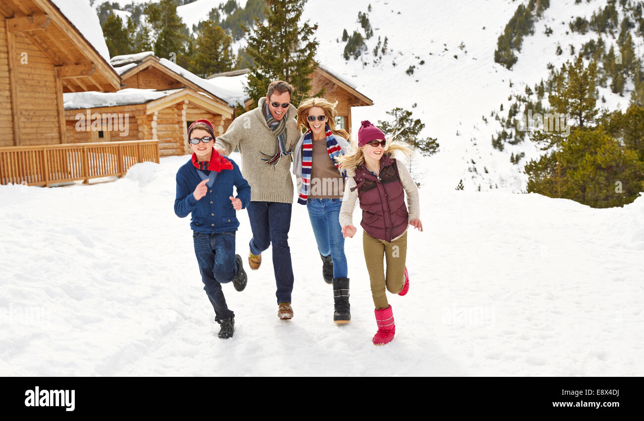 Familie zusammen im Schnee laufen Stockfoto