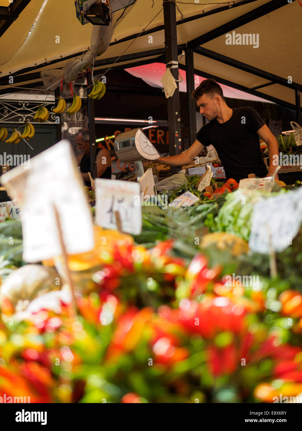 Mann-Betrieb bis zu einem Obst und Gemüse Stand am Markt von Rialto in Venedig, Italien. Bunte Chili im Vordergrund. Stockfoto