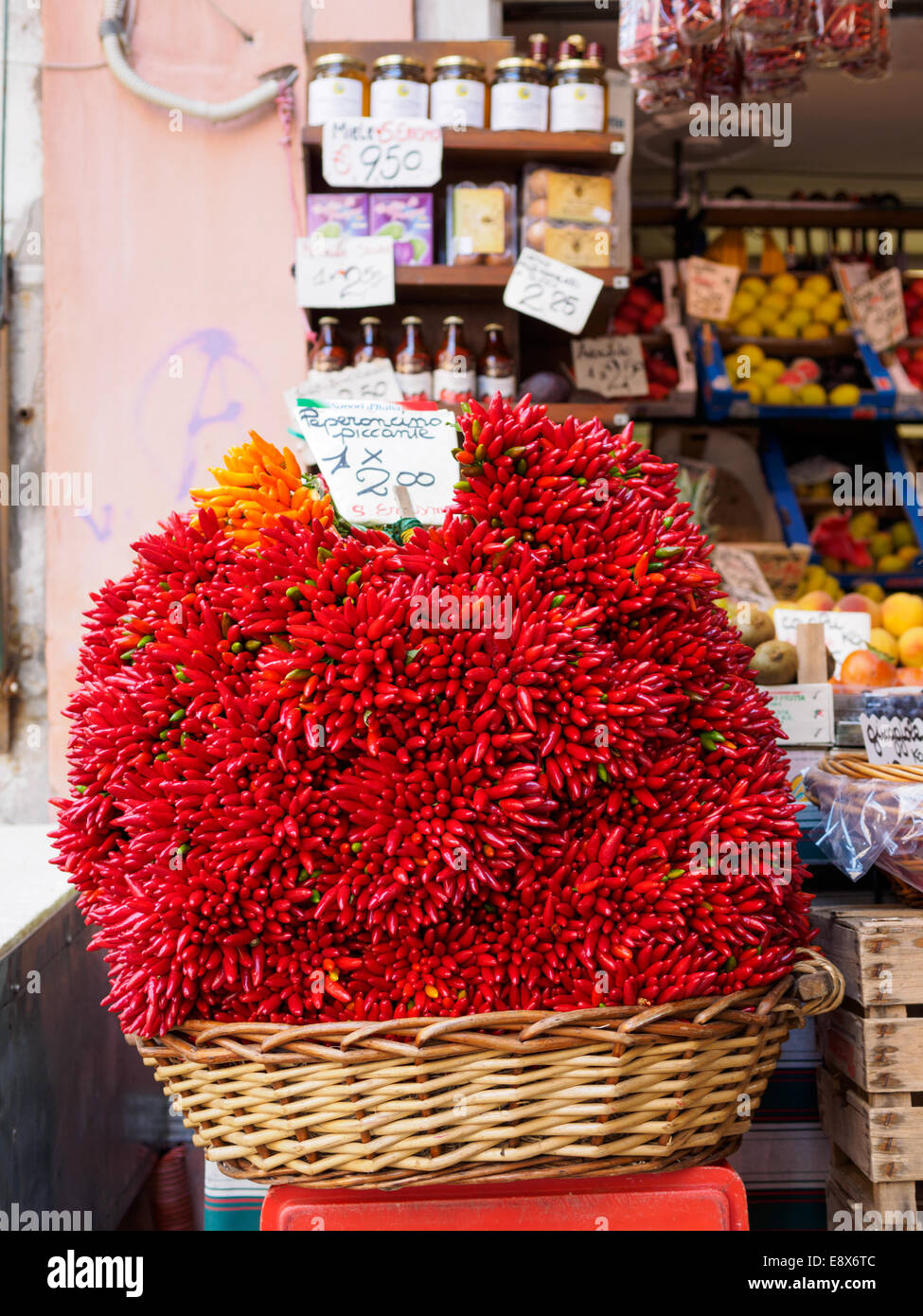 Großer Korb mit Chili auf dem Display auf der Vorderseite einer Filiale von Rialto-Markt in Venedig, Italien. Stockfoto