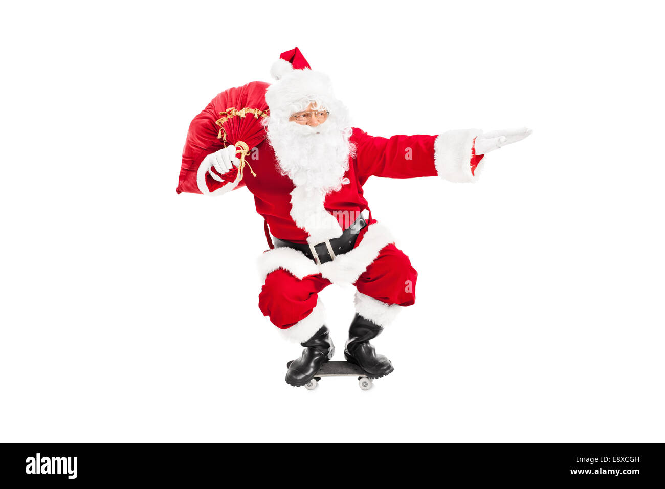 Santa Reiten eine Skateboard und hält eine Tasche voller Geschenke isoliert auf weißem Hintergrund Stockfoto