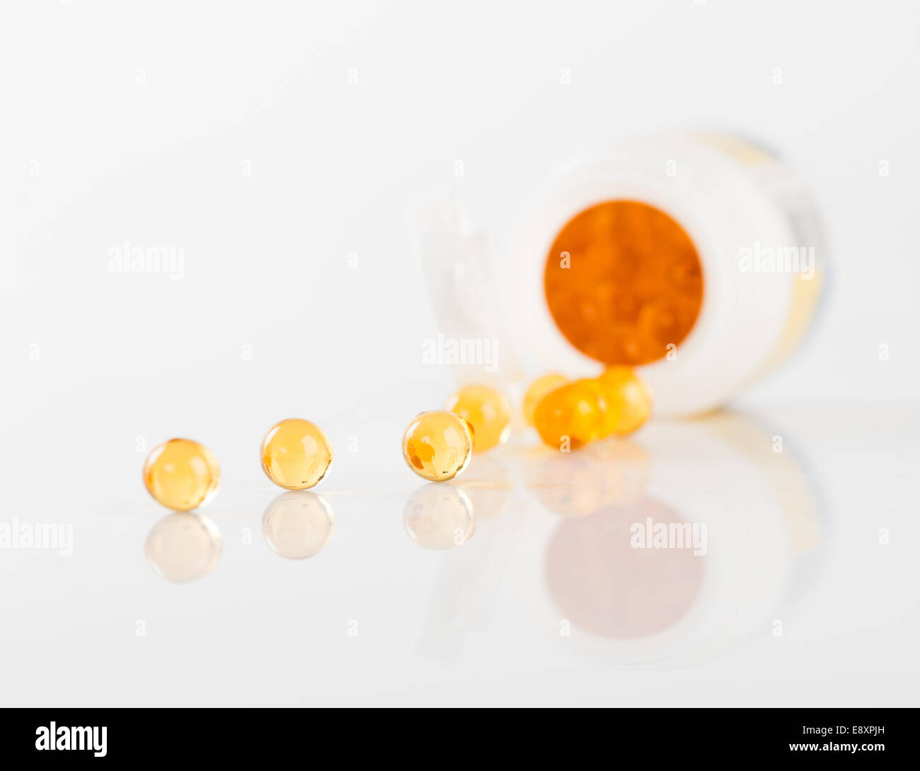 Fischöl-Kapseln ergoss sich offenen Behälter Stockfoto