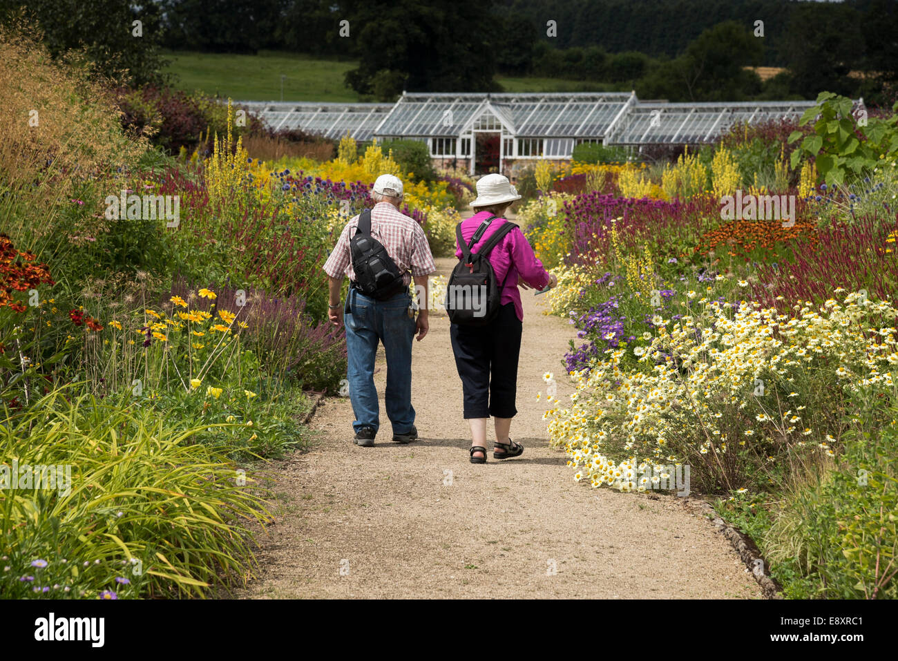 Sommer Besuch in Helmsley ummauerten Garten & 2 Besucher (Paar) Spaziergang auf dem Weg in wunderschöne Blumen auf Grenzen - North Yorkshire, England, UK. Stockfoto