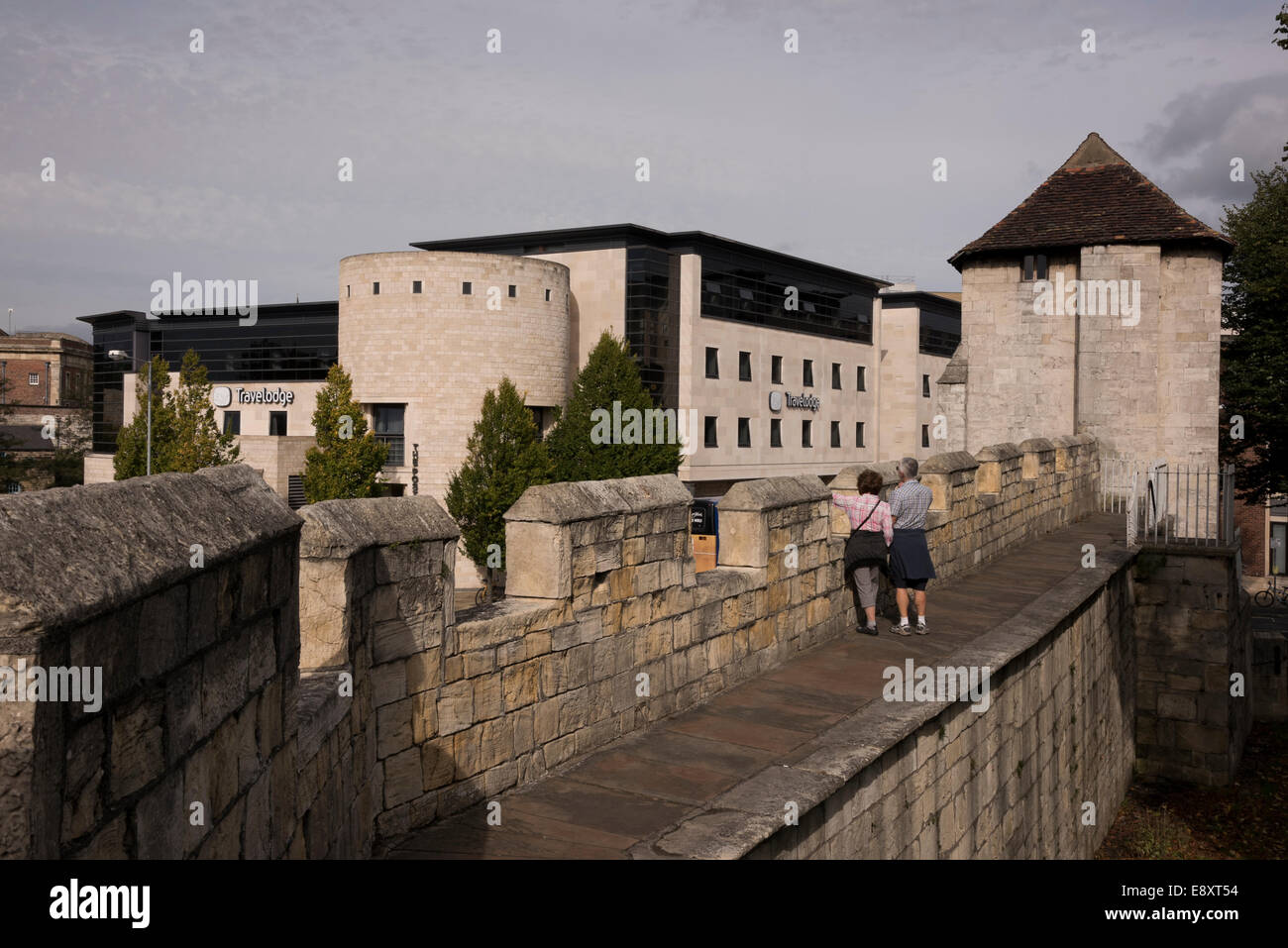 Leute auf historischen Stadtmauern Wall-Walk am alten Fishergate Tower (moderne Architektur des Travelodge Hotel darüber hinaus) - York, North Yorkshire, England. Stockfoto