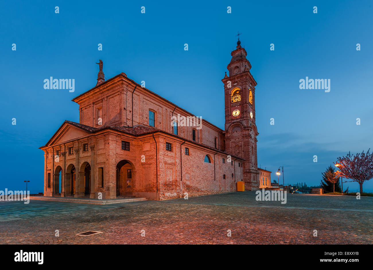 Alte katholische Kirche am kleinen Stadtplatz am Morgen im Piemont, Norditalien. Stockfoto