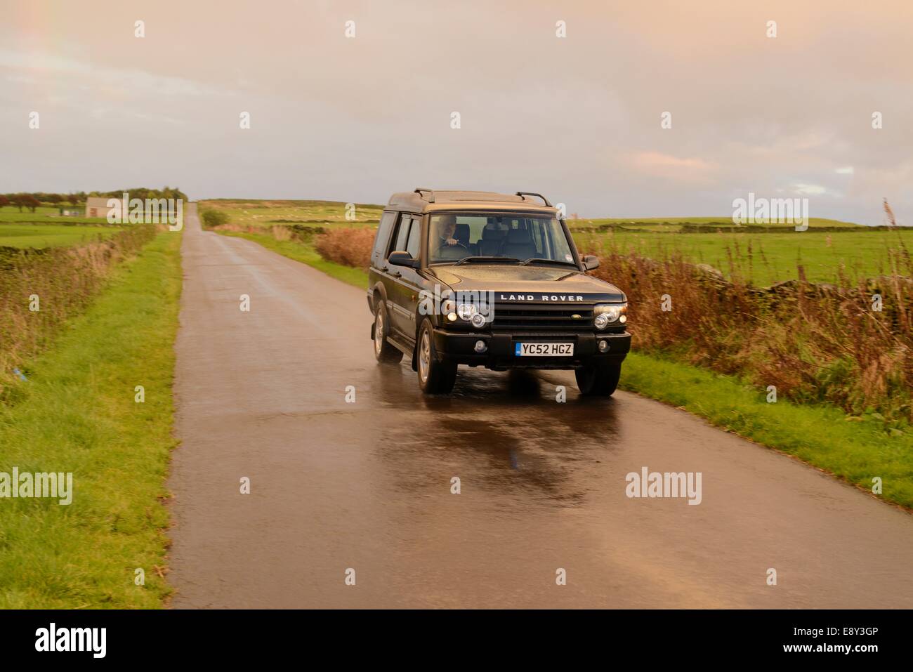 Ein Land Rover Discovery fahren auf einem Feldweg an einem verregneten Tag Stockfoto